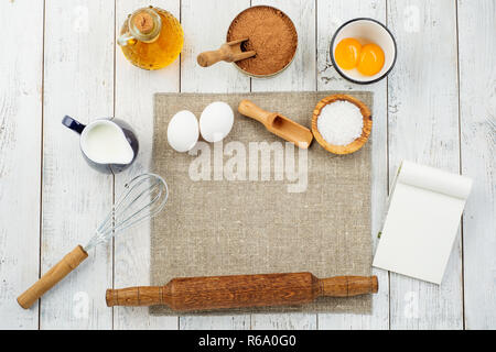 Flat lay or overhead view of baking tools and ingredients on wooden background. Stock Photo