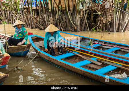 MY THO, VIETNAM - NOVEMBER 24, 2018: Mekong River Delta jungle cruise with unidentified craftman and fisherman rowing boats on flooding muddy lotus fi Stock Photo