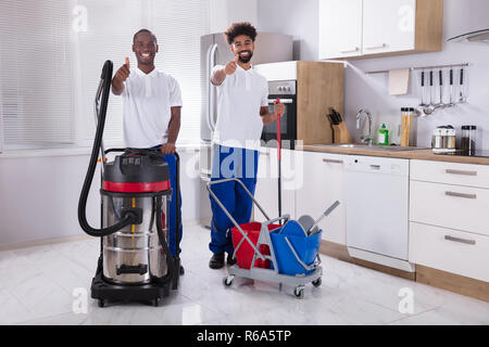 Portrait Of Two Happy Male Janitor In The Kitchen Stock Photo