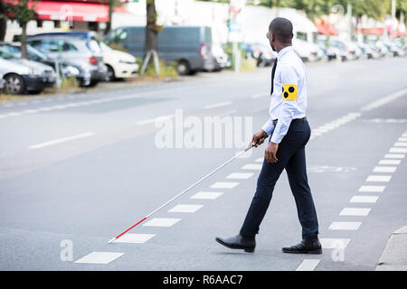 Blind Man Wearing Armband Walking With Stick Stock Photo