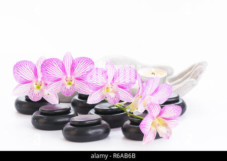 Spa with hot stones and candle on a palm shaped candle holder close up Stock Photo