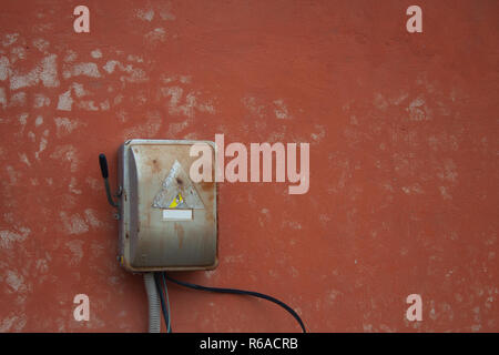 Old power box on red wall. Old electric box Stock Photo