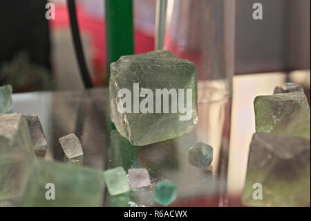 Green Fluorite Natural Octahedron Crystals on glass table Stock Photo