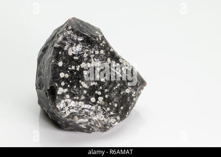 Obsidian: a naturally occurring volcanic glass formed as an extrusive igneous rock, from Vesuvius volcano, isolated on a white background, Naples, Ita Stock Photo