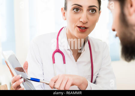 Doctor showing report to the patient on tablet Stock Photo