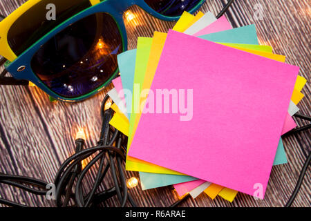 Yellow and blue sticky note with empty space for a text on wooden background. Stock Photo