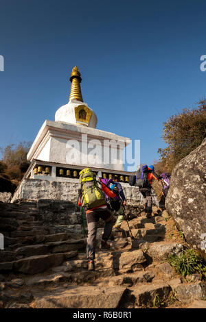 Nepal, Nurning, trekkers climbing stone steps past Buddhist chorten on Everest Base Camp Trek path Stock Photo