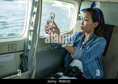 A female Asian model prepares for a Seaplane Flight in Dubai, United Arab Emirates. Stock Photo