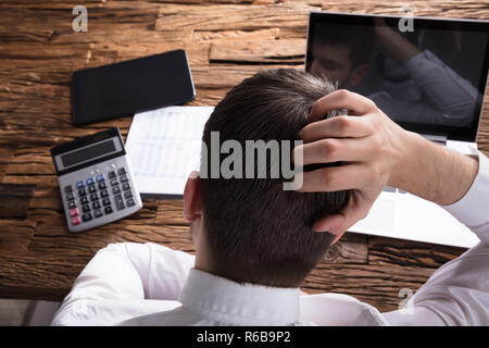 Rear View Of A Stressed Businessman Scratching Head Stock Photo