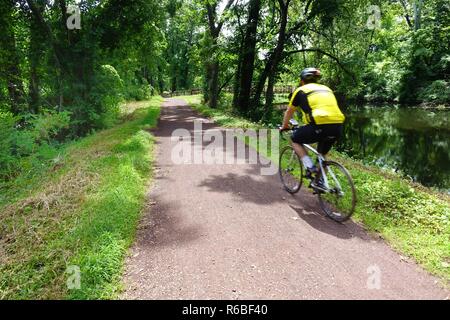 Bicyclist on the Delaware and Raritan Canal towpath, a linear state park in central New Jersey, Stock Photo