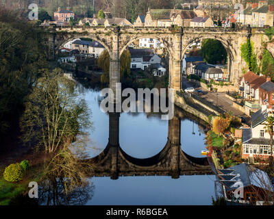 The railway viaduct reflected in the River Nidd on a sunny winter day at Knaresborough North Yorkshire England Stock Photo