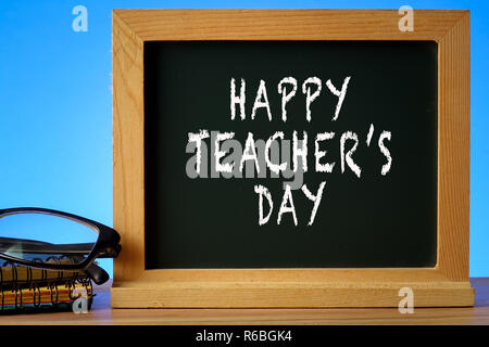 HAPPY TEACHER'S DAY CONCEPT: School stationeries over a blue background. Stock Photo