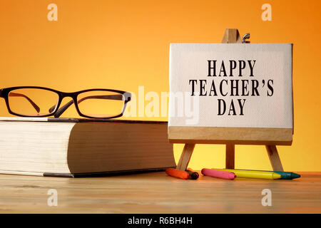 HAPPY TEACHER'S DAY CONCEPT: School stationeries over a orange background. Stock Photo