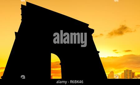 Hot orange sky with  clouds from sunset changing light to dark above cityscape of Arc De Triomphe in Paris France. Stock Photo