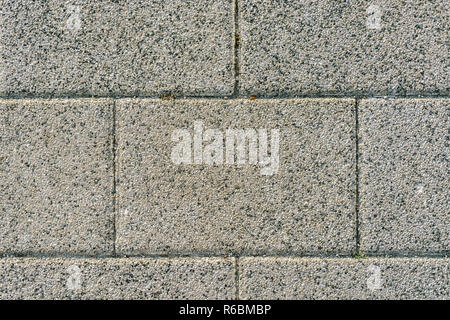 Fragment of a wall made of rectangular pressed small stone slabs for use as a background. Stock Photo