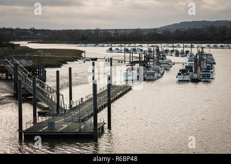 View of a jetty and pier leading to a flotilla of moored yachts on the River Medway in Rochester, England, UK on a cold winter's day, with copy space. Stock Photo