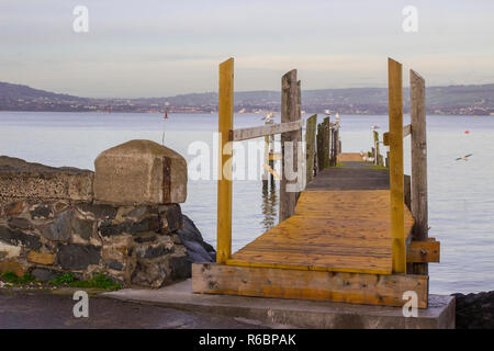 A small wooden pier used by the local yaucht club on The Esplanade at Holywood County Down. Belfast Lough and the distant County Antrim shore can be s Stock Photo