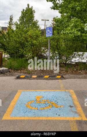 CANMORE, ALBERTA, CANADA - MAY 2018: Symbol marked on the surface of a parking bay reserved for disabled persons at a hotel in Canmore, Alberta