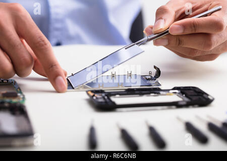 Technician Fixing Damaged Screen On Mobile Phone Stock Photo