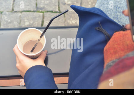 A woman's hand holds a paper cup of coffee Stock Photo