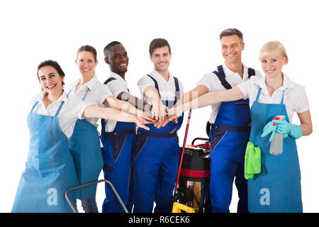 Group Of Happy Janitors Stacking Hands Stock Photo