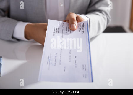 Businessperson Giving Cheque In Office Stock Photo