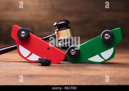 Collision Of Wooden Two Toy Cars In Front Of Gavel Stock Photo