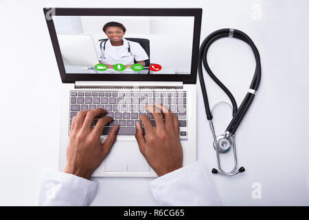 Doctor Video Conferencing With Colleague On Laptop Stock Photo