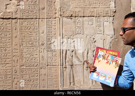 A tour guide explains the bas relief carvings at the Temple of Kom Ombo, in Kom Ombo, Egypt. Stock Photo