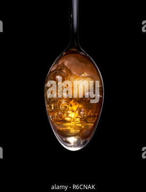 View from above of amber coloured heroin bubbling on a spoon Stock Photo