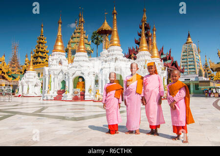 Young Buddhist Nuns At Shwedagon Paya, The Most Sacred Golden Buddhist Pagoda In Yangon, Myanmar Stock Photo