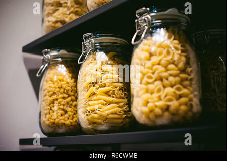 pasta in the jar. on kitchen shelves are different kinds of pasta in glass jars Stock Photo