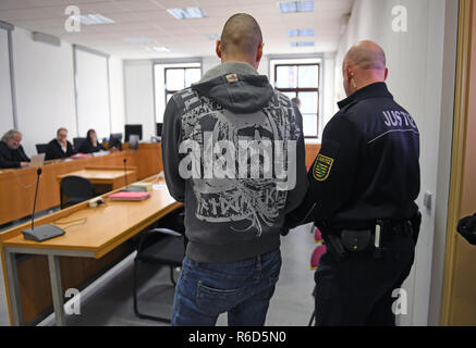 05 December 2018, Saxony, Chemnitz: One in three defendants is taken by a judicial officer to the courtroom of the Chemnitz Regional Court. The three Germans, aged between 22 and 26, are said to have killed an acquaintance on the night of 18 April 2018. They are said to have been extremely brutal and to have severely maltreated the 27-year-old victim. Photo: Hendrik Schmidt/dpa-Zentralbild/dpa Stock Photo