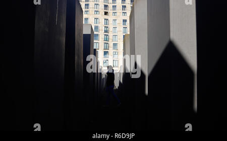 Berlin, Germany. 05th Dec, 2018. A young woman walks through the stelae field of the Holocaust Memorial. Credit: Clara Margais/DPA/Alamy Live News Stock Photo