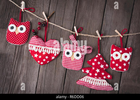 Christmas ornaments hanging on string over wooden background. New Year's card Stock Photo