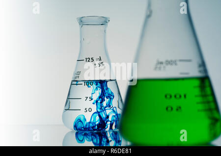 Two conical flasks containing green and blue liquids Stock Photo