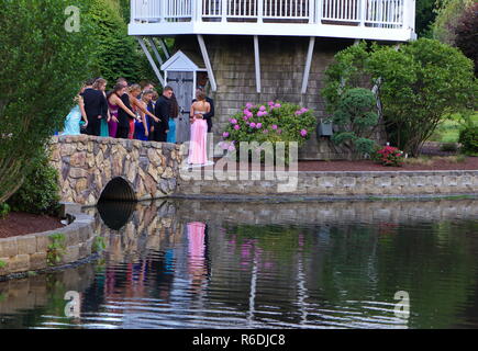 Plainville, CT USA. June 2013. Seniors watching fish in the pond as they wait for the formal photo shoot. Stock Photo