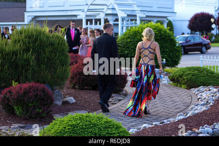 Plainville, CT USA. June 2013. A young man looking and escorting his date clad in an unique dress to the prom. Stock Photo