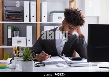 Unhappy Businessman Working In Office Stock Photo