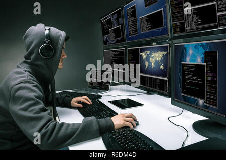 Hacker Using Multiple Computers For Stealing Data Stock Photo