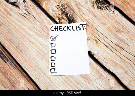 Close up of pin and to do list Checklist word on sticky note with wooden background Stock Photo