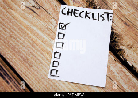 Close up of pin and to do list Checklist word on sticky note with wooden background Stock Photo