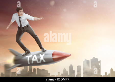 Happy asian businessman flying on rocket with Tax text Stock Photo