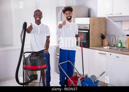 Portrait Of Two Happy Male Janitor In The Kitchen Stock Photo