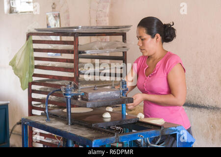 SAN JOSE DEL CABO, MEXICO -MARCH 16, 2012: Local woman makes home made  tortillas from corn dough in a small bakery in San JOse del Cabo, Mexico Stock Photo