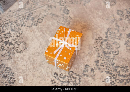 Gift box on white background. Present in craft and colored paper decorated with white satin ribbon bows. Christmas and other holidays concept. Stock Photo