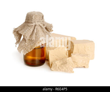 A block of compressed fresh yeast with pharmaceutical bottle. Stock Photo