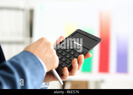 Male arm in suit hold calculator pressing buttons Stock Photo