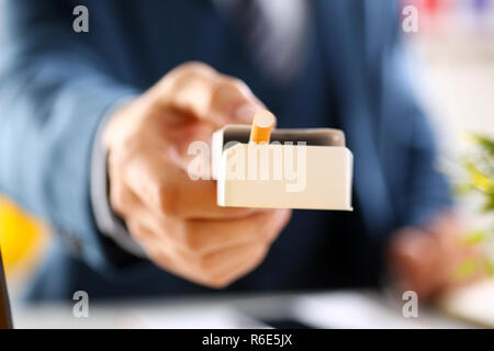 Male arm in suit offer pack of cigarettes Stock Photo