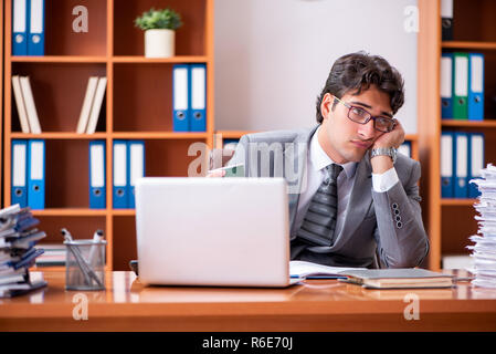 Young handsome businessman unhappy with excessive work Stock Photo